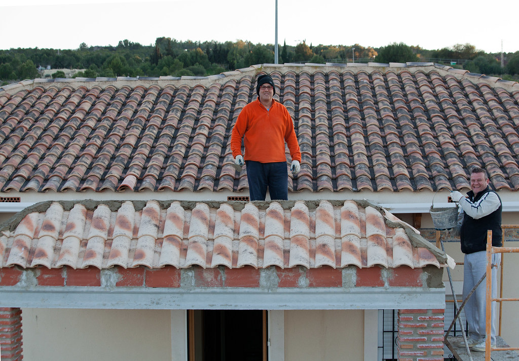 Roof tilers working on a terracotta tile roof