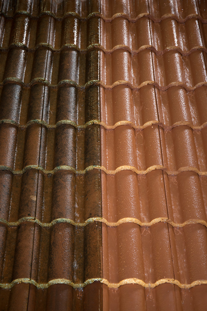Close up of clean roof tile beside grime after high pressure cleaning